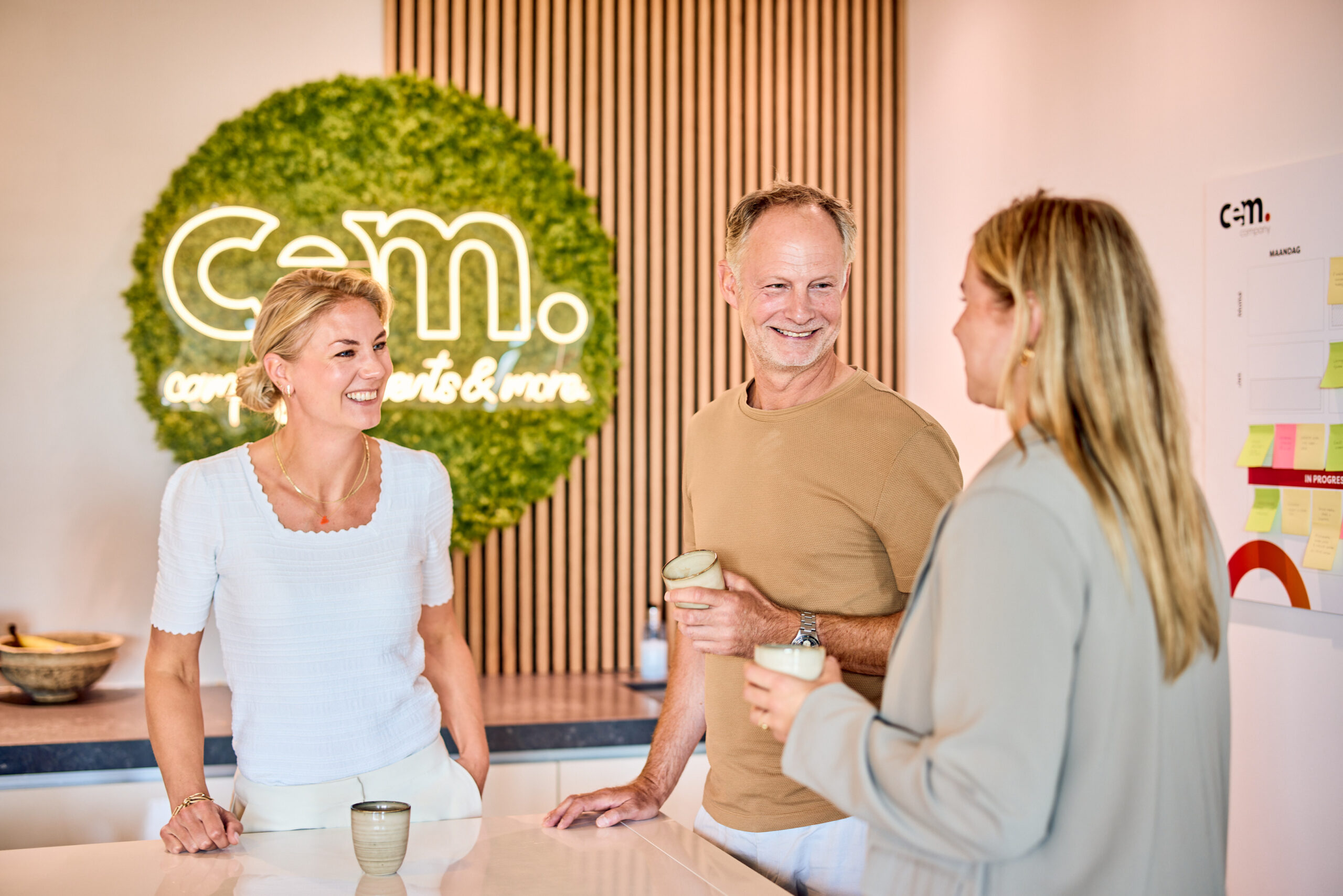 Werknemers van campagne- en evenementenbureau CEM Company drinken koffie op kantoor